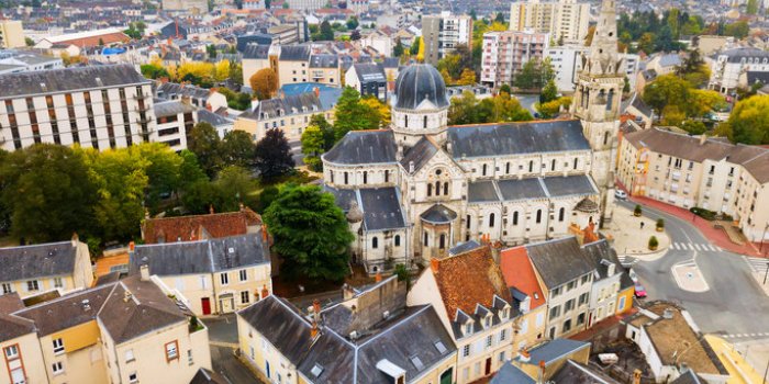 aerial view of ancient church notre-dame in french commune of chateauroux on background with peculiar townscape