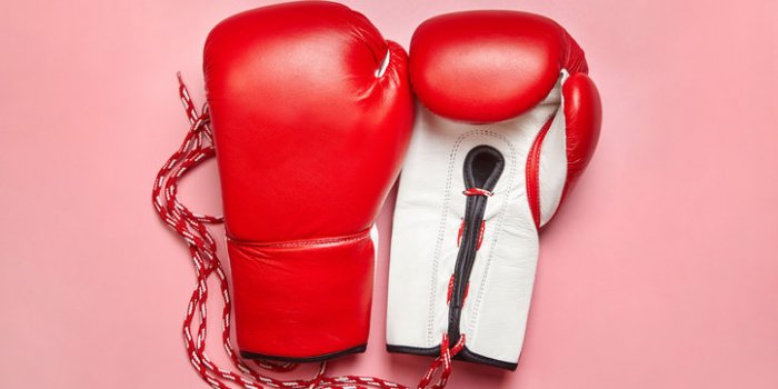 red professional boxing gloves on pink background women self-defense
