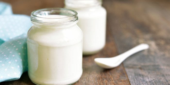 homemade yogurt in a glass jar on a wooden table