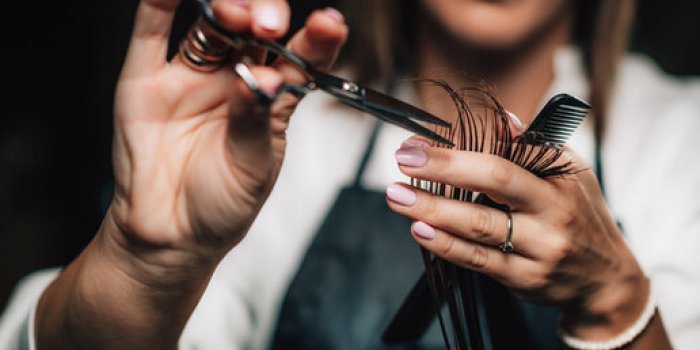 close-up of a hairdresser cutting womanâs hair