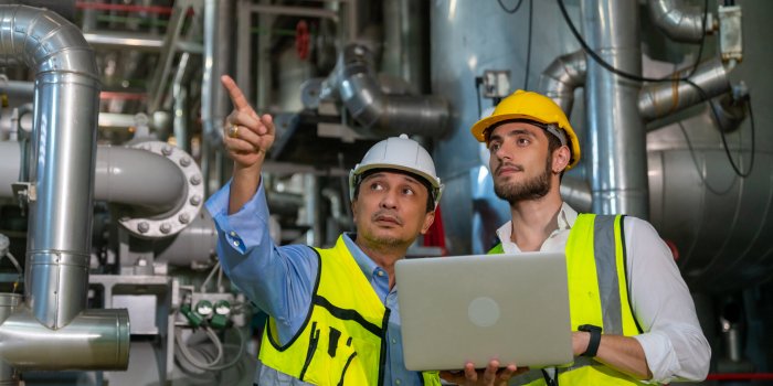 two professional electrical engineer in safety uniform working t