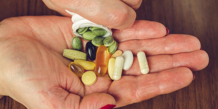 woman's hands poured the mix of vitamins and nutritional, dietary supplement pills from a bottle, close-up