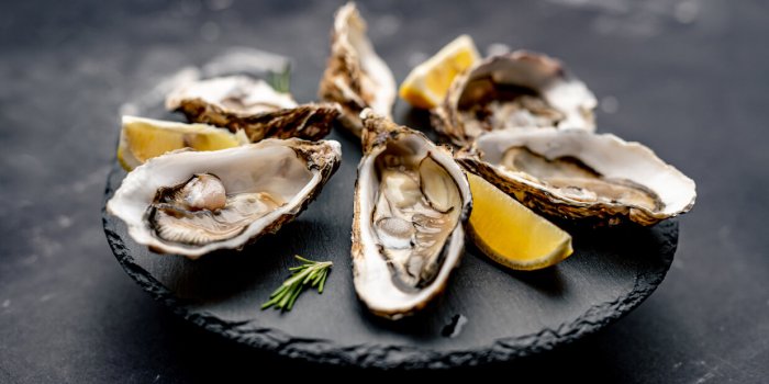 oysters with lemon served on black round platter luxury delicatessen seafood