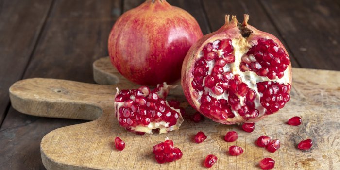 pomegranates on the cutting board on the old wooden kitchen table vegan and vegetarian food healthy eating ecological agr...