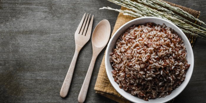 brown rice coarse rice with wooden spoon and fork, rice seed top view