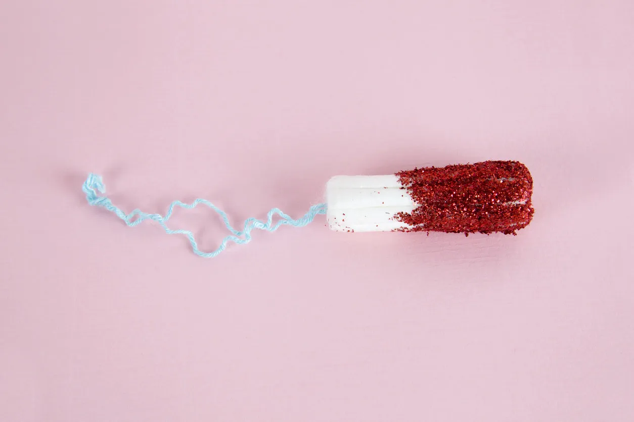 a hygienic tampon with red glitters instead of bloodnminimal color still life and quirky photography