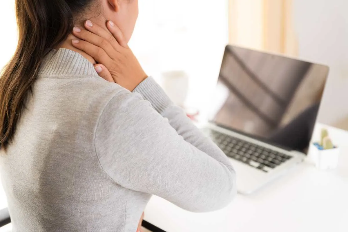 closeup woman with hands holding her shoulder pain office syndrome and health care concept