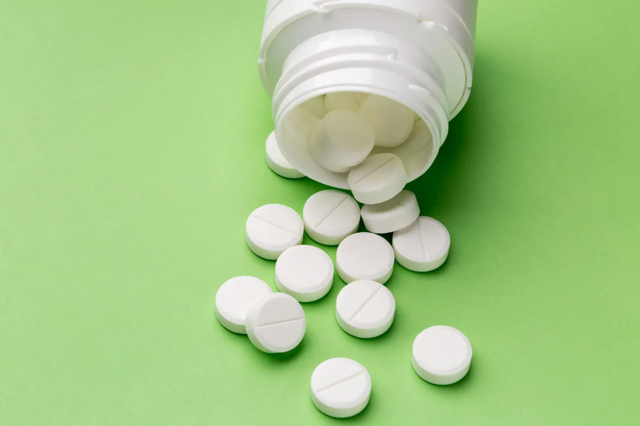 heap of round white tablets and plastic pills bottle heap of round white tablets and plastic pills bottle