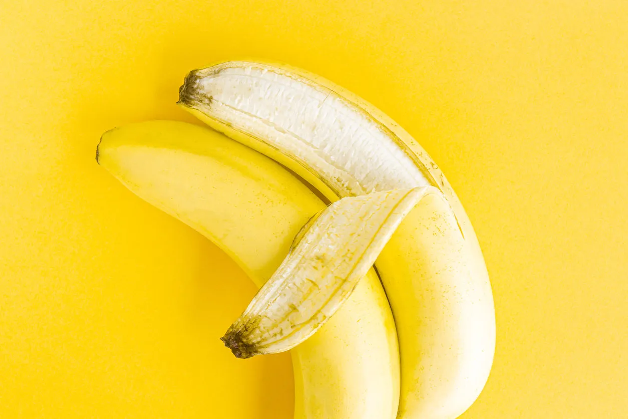 concept of same-sex lgbt love, two bananas hugging on a yellow pastel background concept of same-sex lgbt love, two bananas hugging on a yellow pastel background