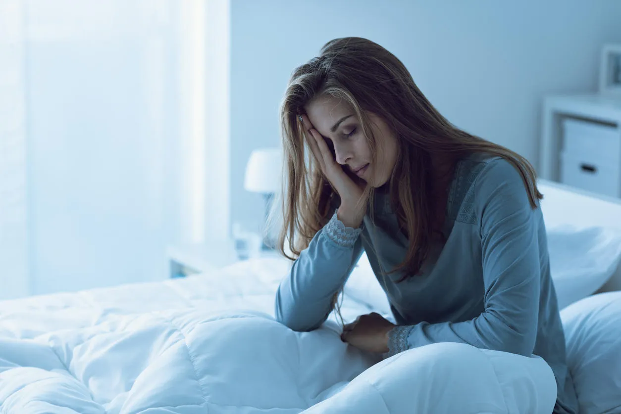 depressed woman awake in the night, she is touching her forehead and suffering from insomnia depressed woman awake in the night, she is touching her forehead and suffering from insomnia
