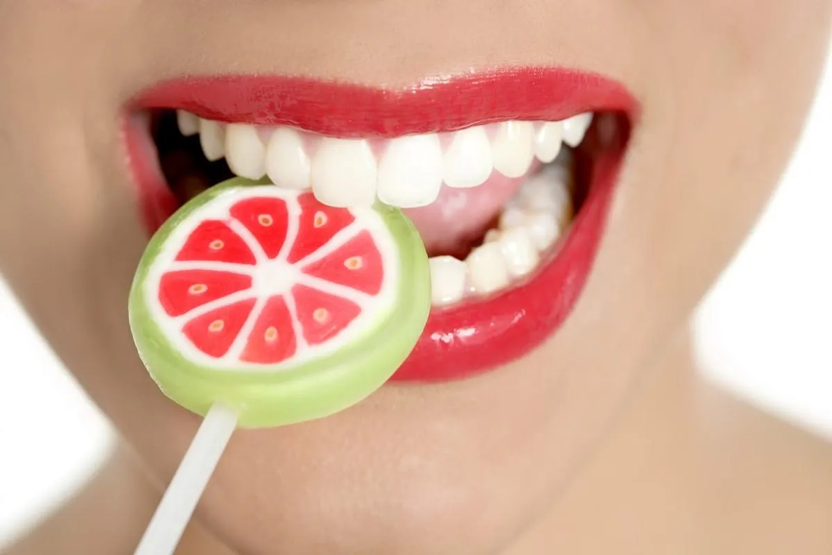 sucette colorée dans les dents de la femme parfaite et la bouche des lèvres rouges sucette colorée dans les dents de la femme parfaite et la bouche des lèvres rouges
