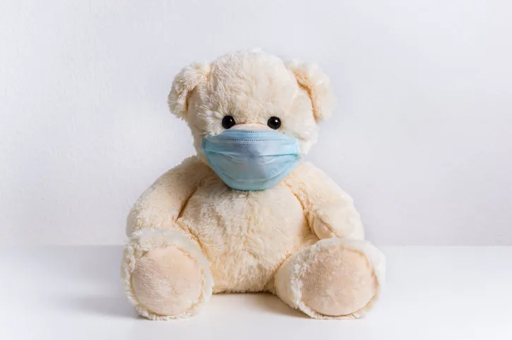cute teddy bear with protective medical mask on his face concept of of illness, hygiene and virus protection for child patient during epidemic fluffy toy on white background