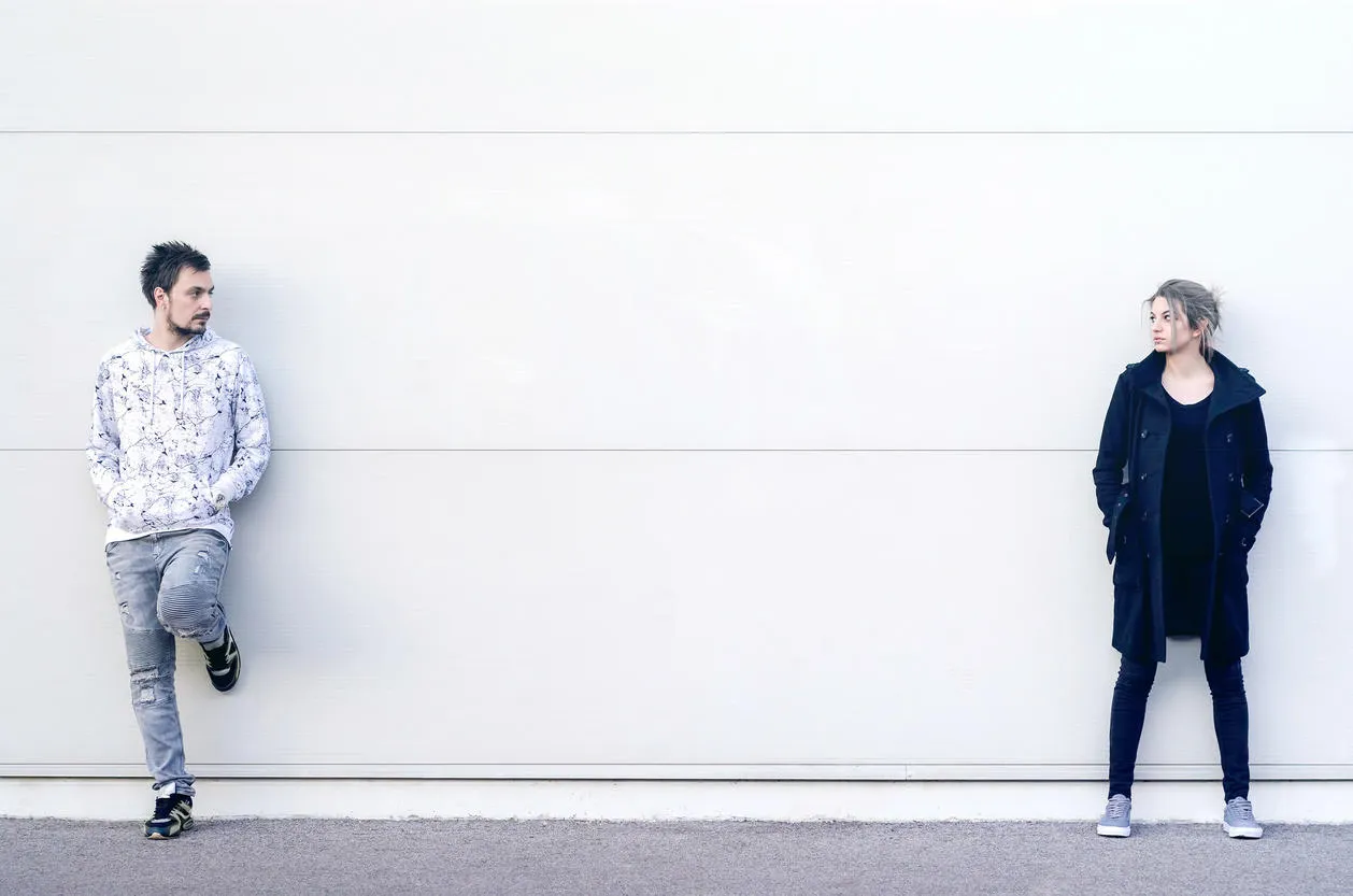 young man and woman looking at each other from distance young man and woman looking at each other from distance