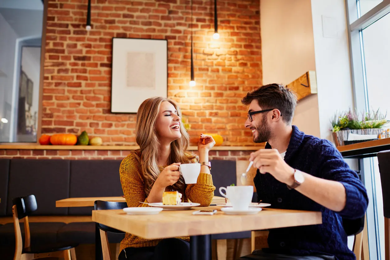 couple of young people drinking coffee and eating cake in a stylish modern cafeteria couple of young people drinking coffee and eating cake in a stylish modern cafeteria