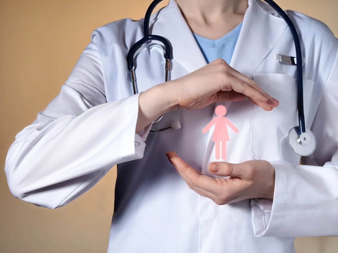 a woman doctor holds a woman's pictograph in her hands female doctor with a stethoscope gesticulating on a beige background a woman doctor holds a woman's pictograph in her hands female doctor with a stethoscope gesticulating on a beige background