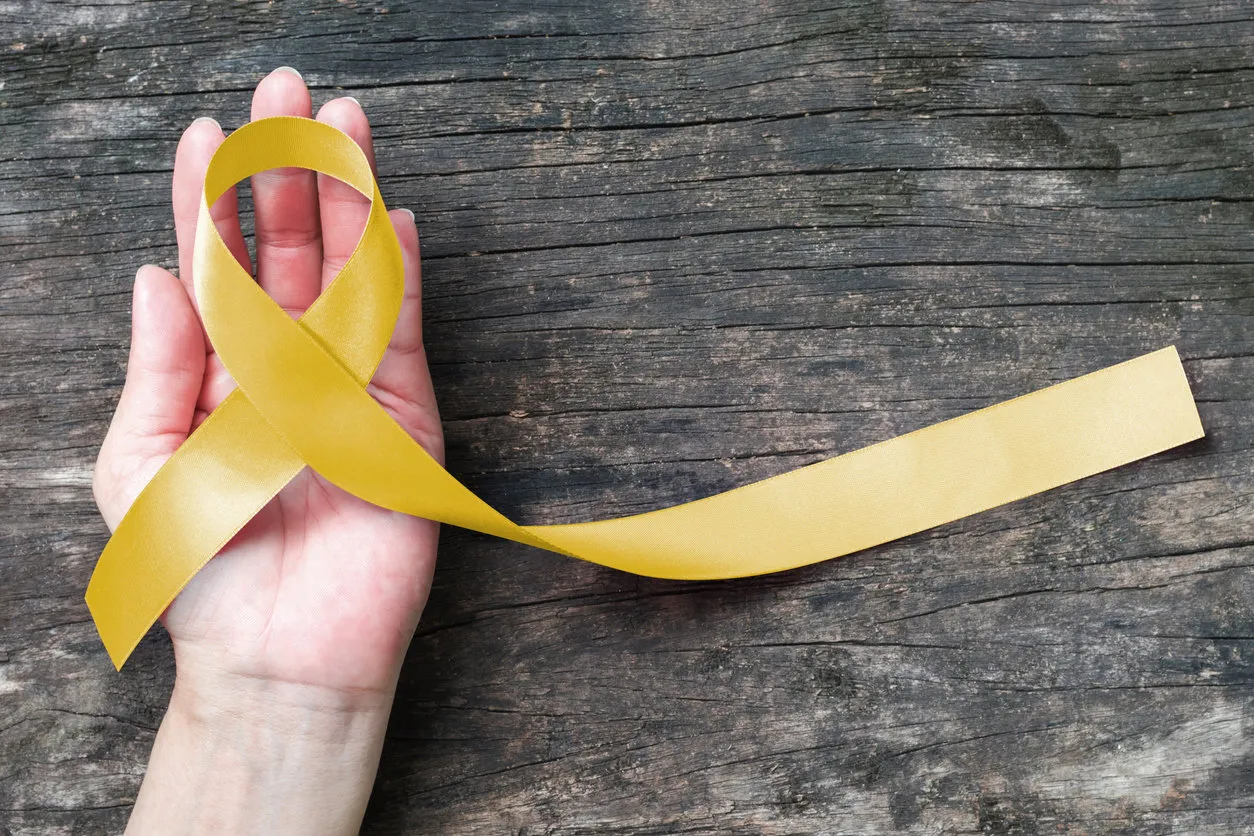 yellow ribbon symbolic color for sarcoma bone cancer, spina bifida awareness month and suicide prevention on helping hand (isolated with clipping path) yellow ribbon symbolic color for sarcoma bone cancer, spina bifida awareness month and suicide prevention on helping hand (isolated with clipping path)