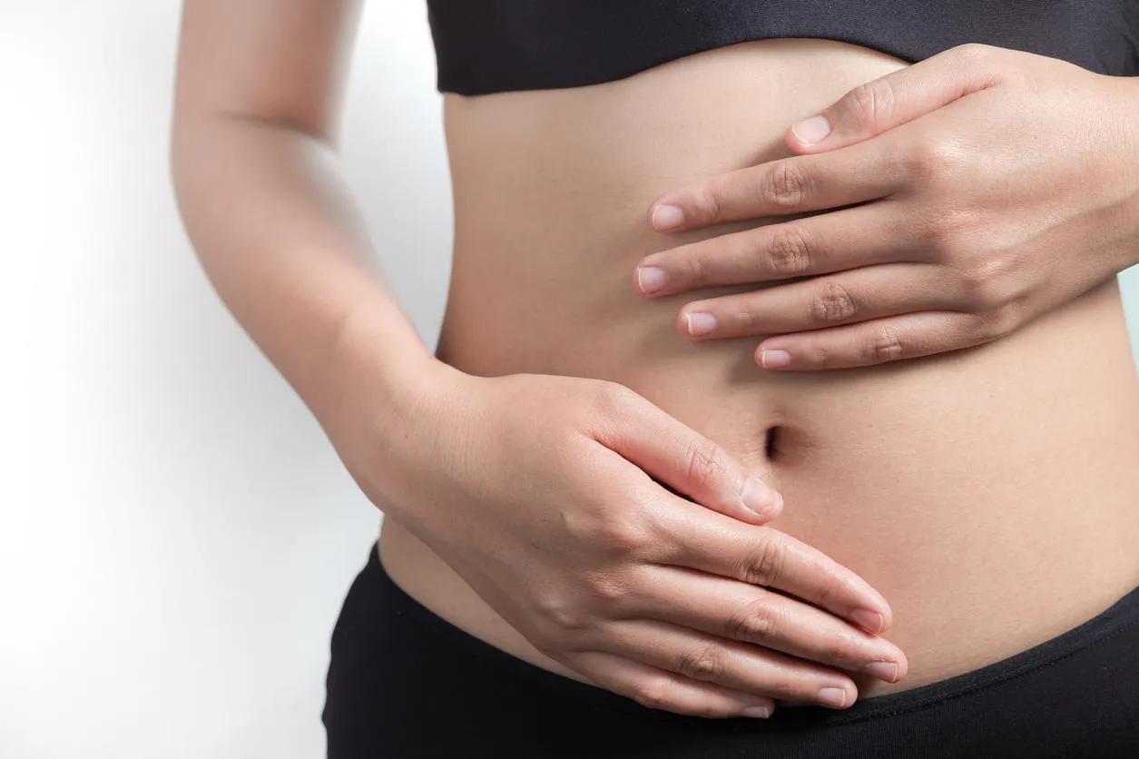 pregnancy or diet concept, female hands protecting the stomach on white background pregnancy or diet concept, female hands protecting the stomach on white background