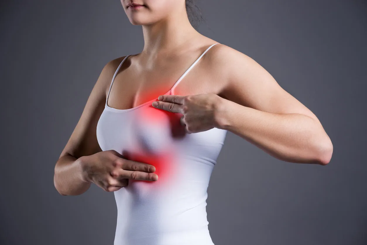 breast test, woman examining her breasts for cancer, heart attack, pain in human body on gray background breast test, woman examining her breasts for cancer, heart attack, pain in human body on gray background