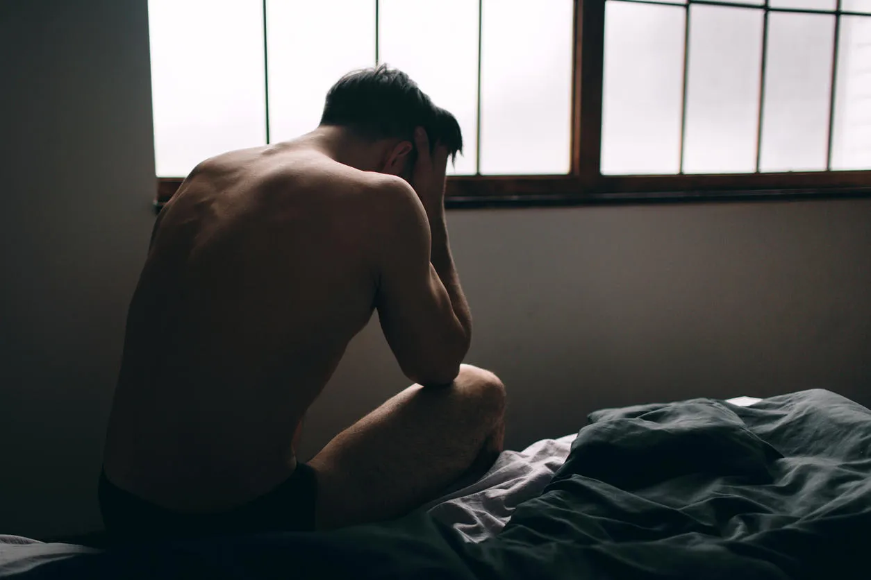 depressed man sitting on bed in an empty room this is major depressive disorder depressed man sitting on bed in an empty room this is major depressive disorder