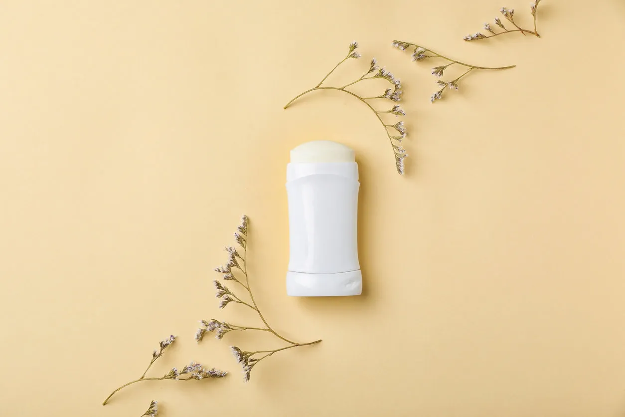 white deodorant and herbs on color background white deodorant and herbs on color background