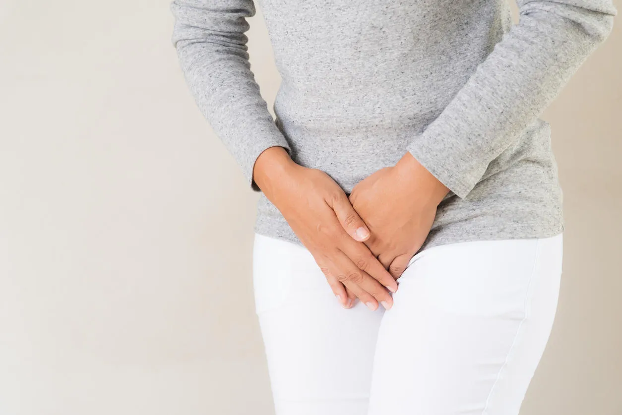 young woman having painful stomachache with hands holding pressing her crotch lower abdomen medical or gynecological problems, healthcare concept