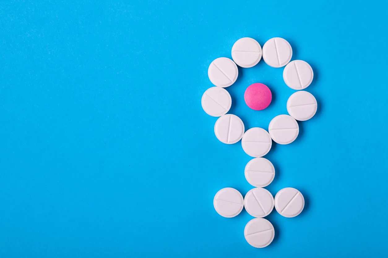 gender symbol of woman from pills on blue background top view with copy space place for text, concept about female health