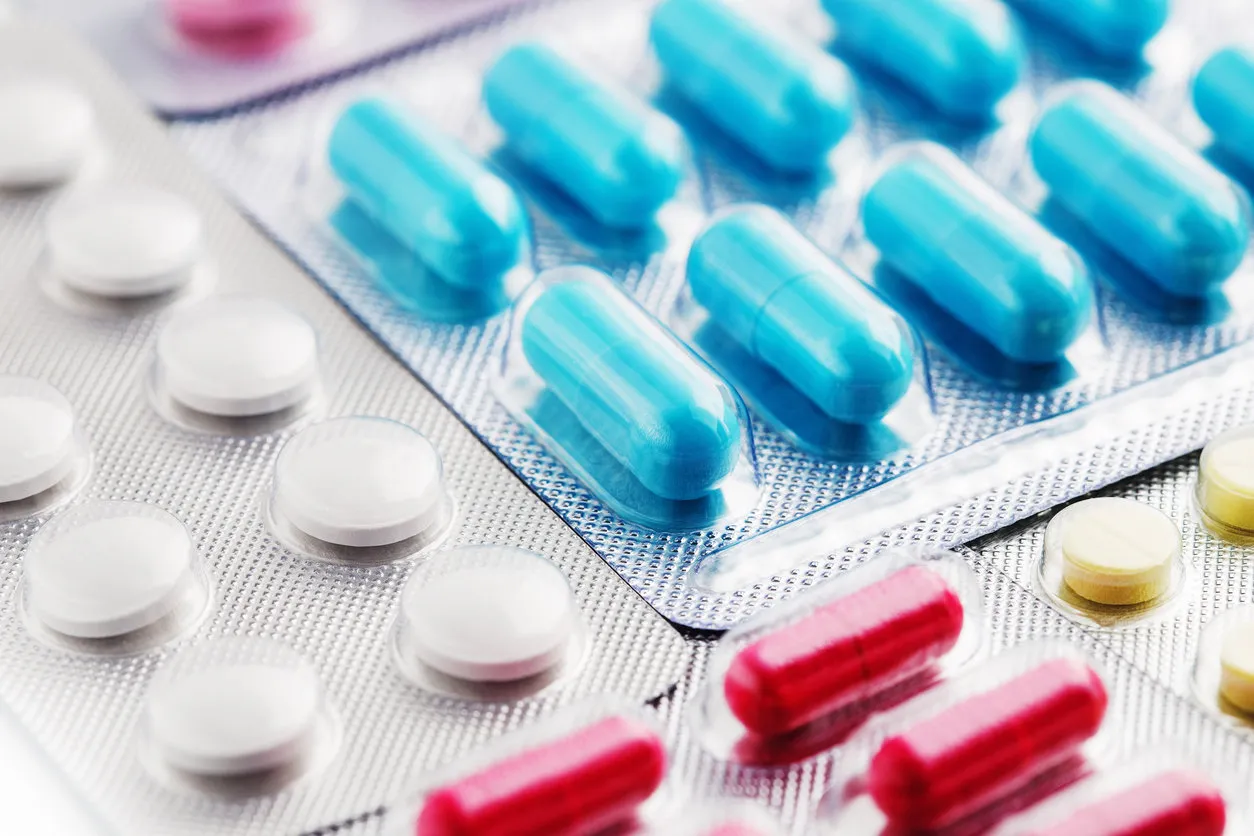 heap of medical pills in white, blue and other colors pills in plastic package concept of healthcare and medicine