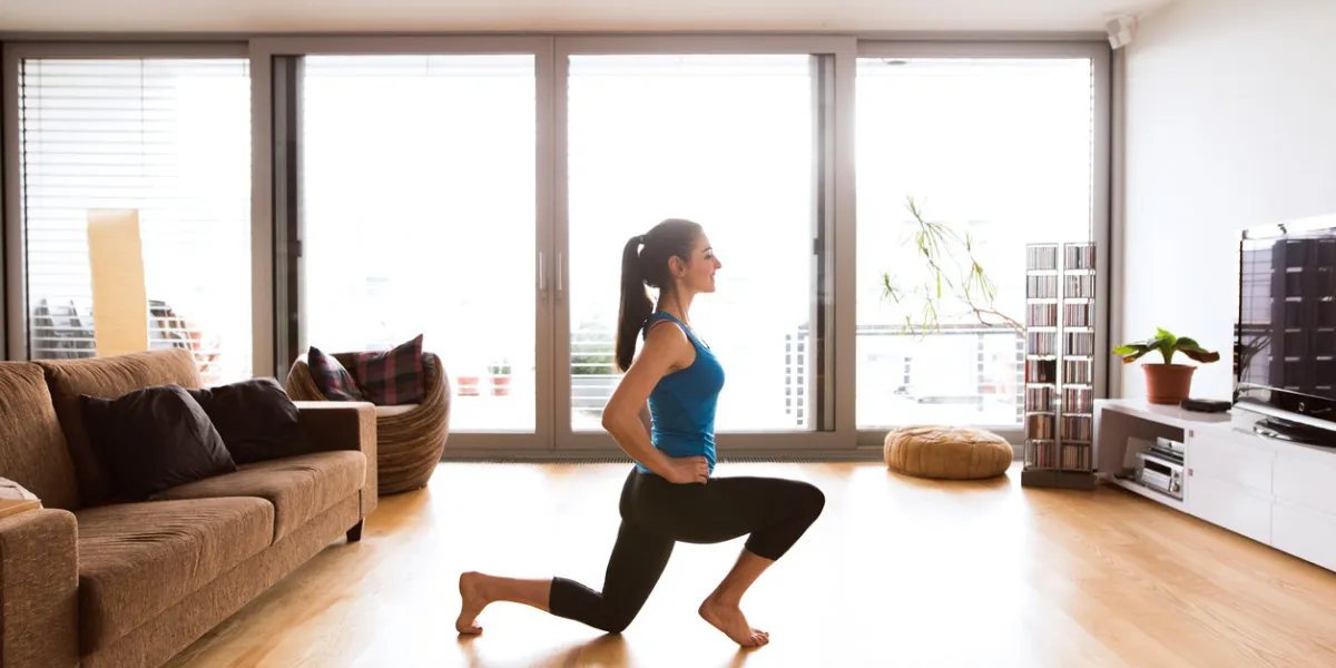 beautiful young woman working out at home in living room, doing yoga or pilates exercise, stretching legs beautiful young woman working out at home in living room, doing yoga or pilates exercise, stretching legs
