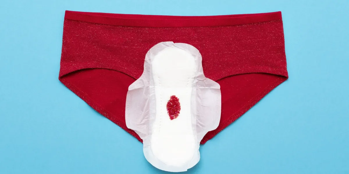menstruation period concept red drop from beads on pants on blue background menstruation period concept red drop from beads on pants on blue background