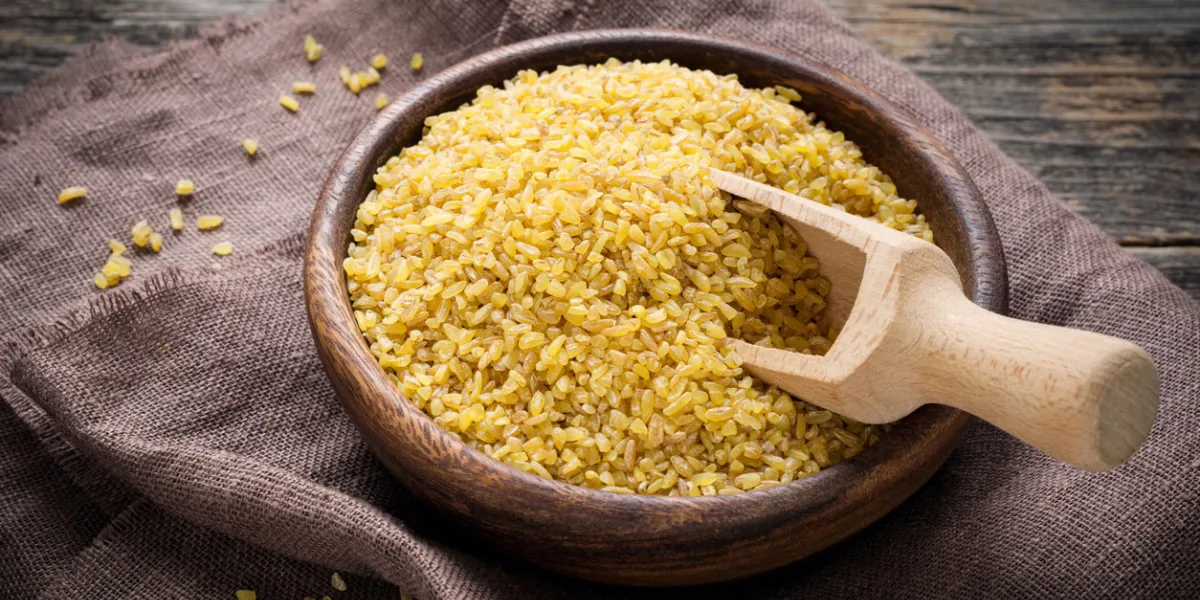 raw bulgur in wooden bowl on brown textile, close up shot healthy, dietary, vegan, gluten free product raw bulgur in wooden bowl on brown textile, close up shot healthy, dietary, vegan, gluten free product