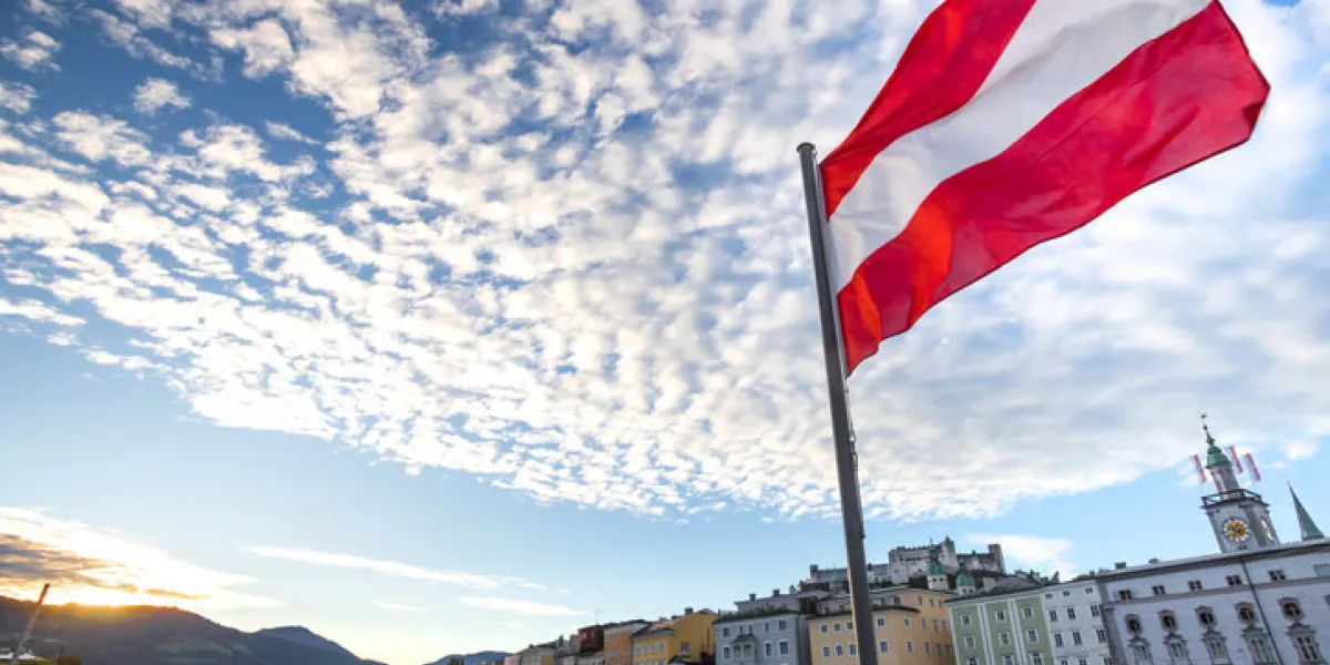 austrian flag over historic salzburg cityscape