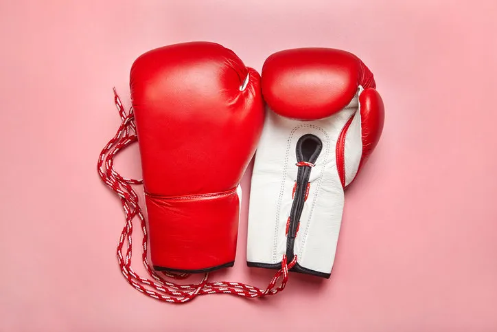 red professional boxing gloves on pink background women self-defense red professional boxing gloves on pink background women self-defense