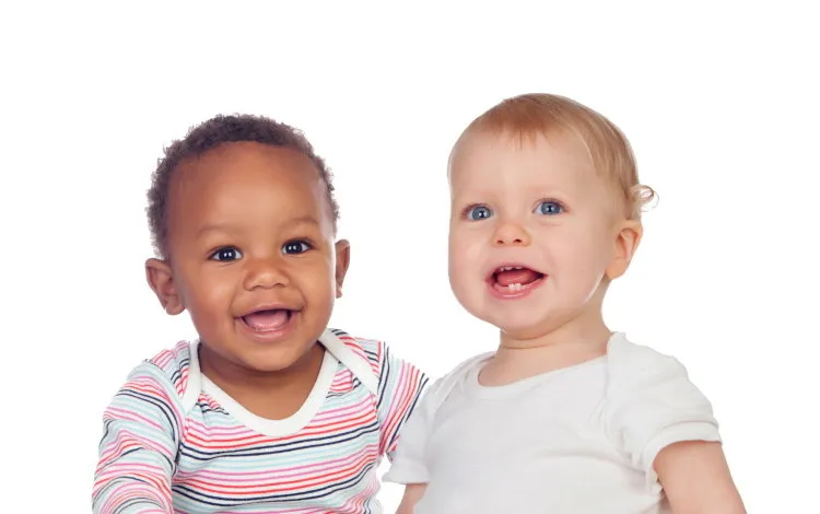 couple of babies african and caucasian laughing on white background couple of babies african and caucasian laughing on white background