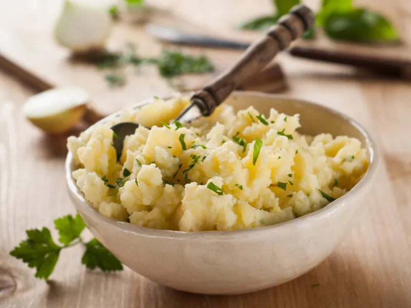 a bowl of mashed potatoes with spoon, selective focus