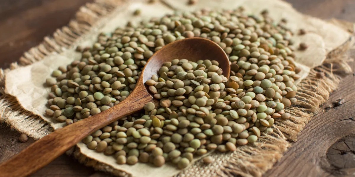 green lentils with a spoon on a wooden table top view green lentils with a spoon on a wooden table top view