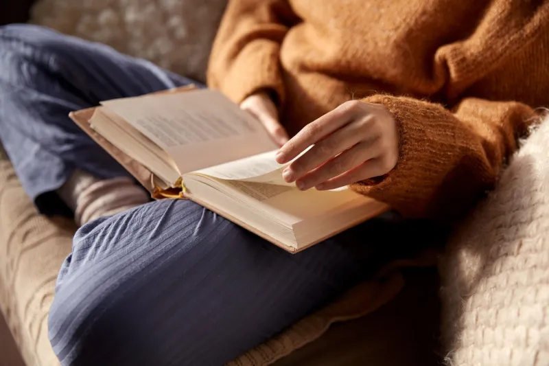 people, season and leisure concept - close up of woman in warm sweater reading book at home people, season and leisure concept - close up of woman in warm sweater reading book at home
