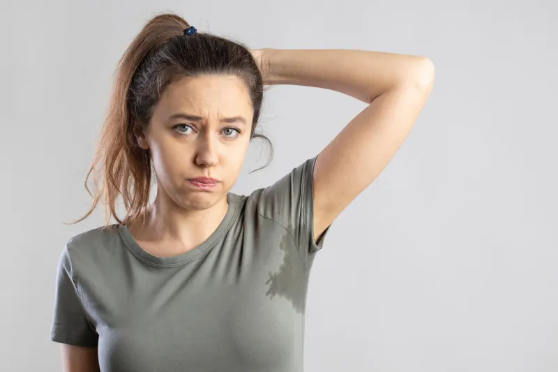 excessive sweating problems young woman with her arm raised with her armpits sweat excessive sweating problems young woman with her arm raised with her armpits sweat