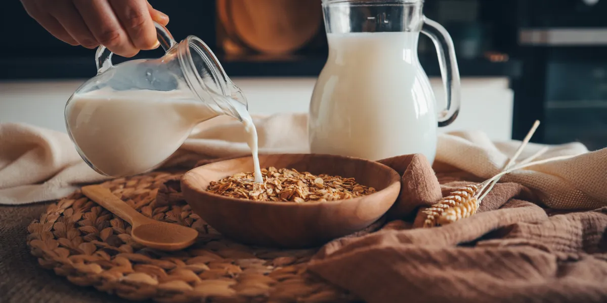 aesthetic breakfast milk jug pouring milk into the bowl with natural muesli made from mix of unprocessed whole grains aesthetic breakfast milk jug pouring milk into the bowl with natural muesli made from mix of unprocessed whole grains