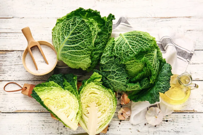 fresh savoy cabbage on light wooden background fresh savoy cabbage on light wooden background