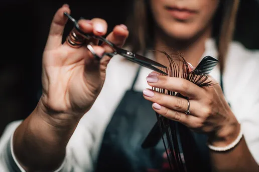 close-up of a hairdresser cutting woman’s hair close-up of a hairdresser cutting woman’s hair