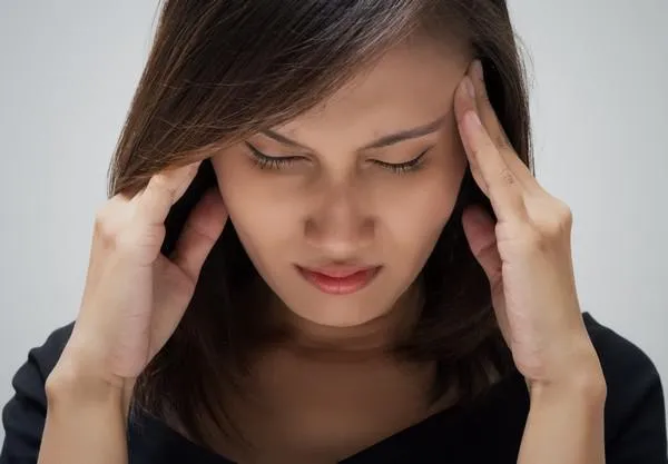 femme ayant un mal de tête femme ayant un mal de tête