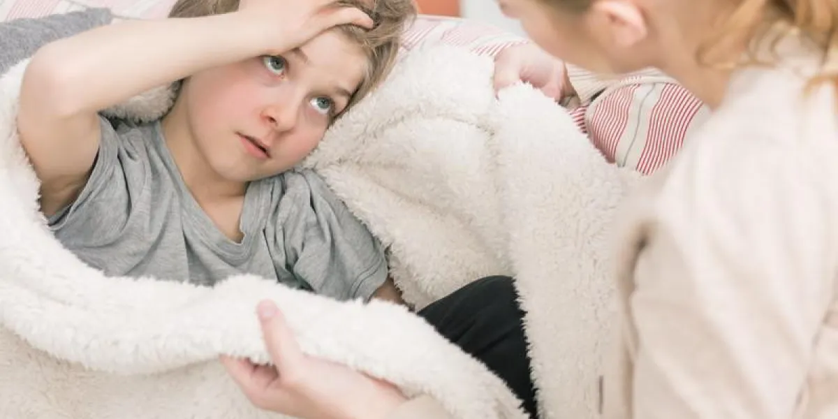 coup d'un petit garçon malade tenant sa tête et parler à sa mère