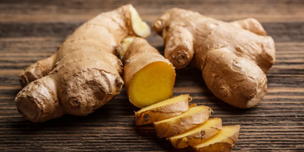 gingembre frais, entier et tranché sur fond en bois rustique gingembre frais, entier et tranché sur fond en bois rustique