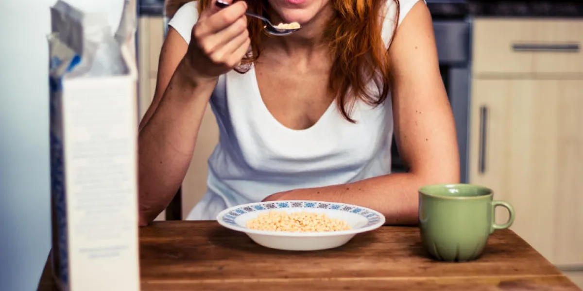 jeune femme ayant des céréales pour le petit déjeuner