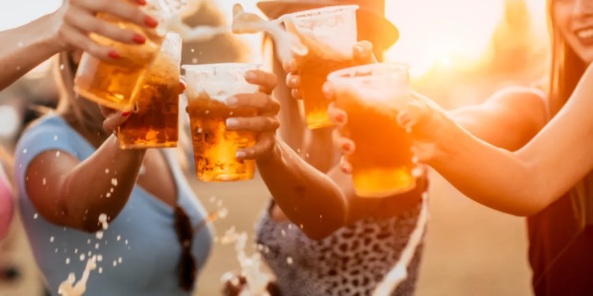 female friends cheering with beer at music festival