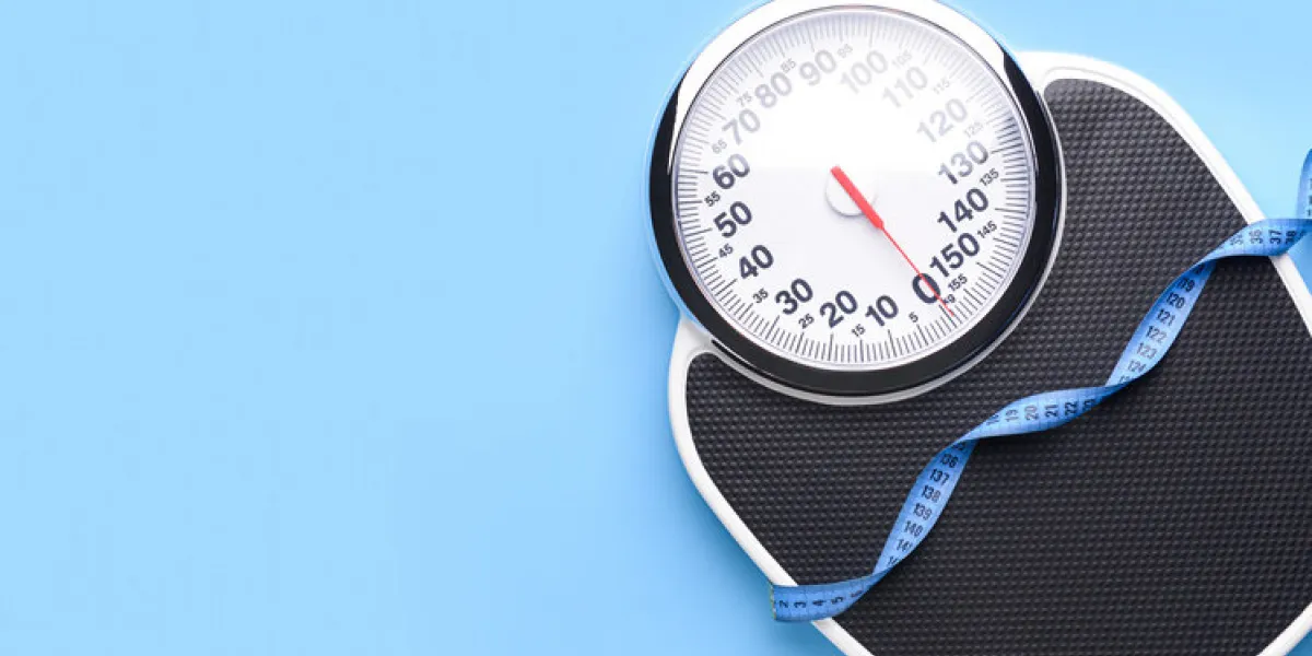 scales and measuring tape on color background weight loss concept