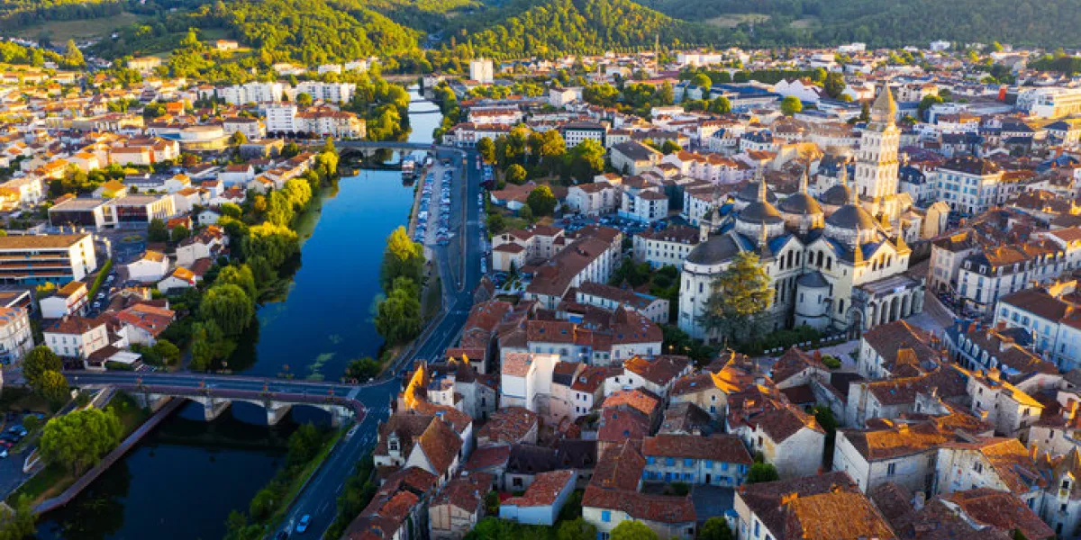 drone view of french city of perigueux on isle river overlooking romanesque building of ancient cathedral during summer sunset