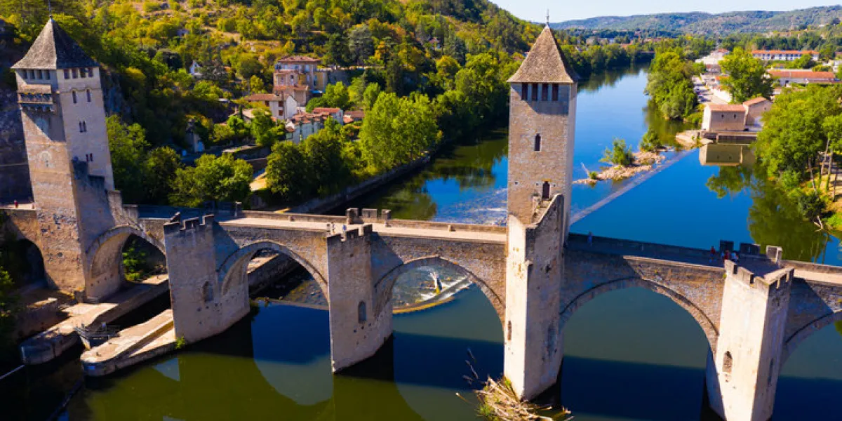 scenic aerial view of medieval arched valentre bridge across lot river in french commune of cahors on summer day