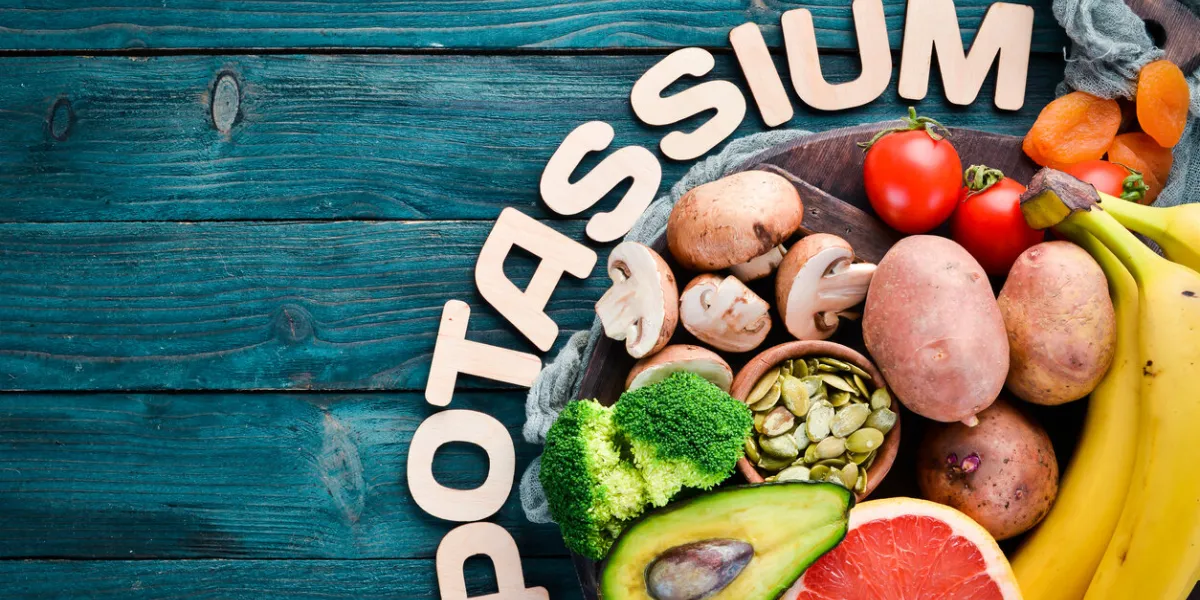 foods containing natural potassium k potatoes, mushrooms, banana, tomatoes, nuts, beans, broccoli, avocados top view on a blue wooden background foods containing natural potassium k potatoes, mushrooms, banana, tomatoes, nuts, beans, broccoli, avocados top view on a blue wooden background