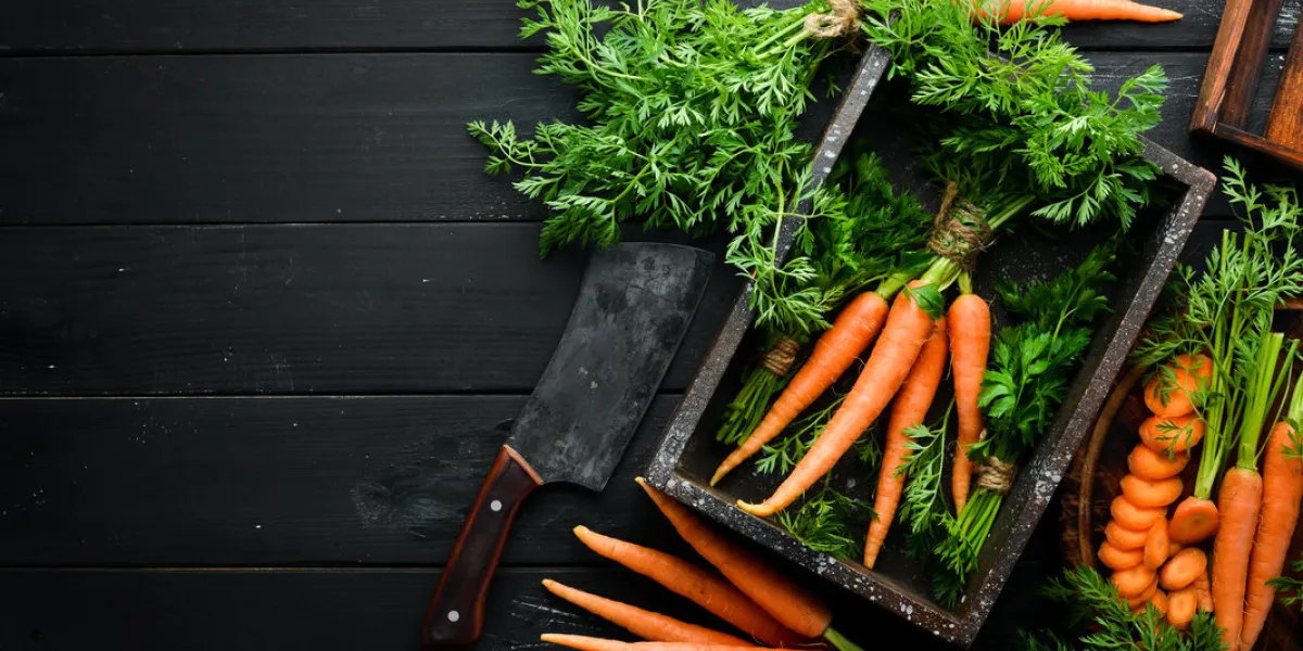 fresh carrots on a black wooden background top view